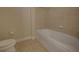 Bathroom featuring tile flooring, a toilet, and a white bathtub with tiled walls at 225 W Seminole Blvd # 213, Sanford, FL 32771