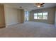 Spacious bedroom with a ceiling fan, neutral carpet, large windows, and sliding glass doors to a balcony at 225 W Seminole Blvd # 213, Sanford, FL 32771