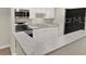 Well-equipped kitchen with white cabinets, stainless steel appliances, and bar-style countertop seating at 2548 Oak Park Way # 102, Orlando, FL 32822