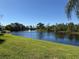 Beautiful pond view with a fountain, framed by palm trees and a well-maintained green lawn at 2548 Oak Park Way # 102, Orlando, FL 32822