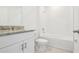 Bright bathroom with granite countertop vanity, white cabinets, and tiled shower/tub combo at 2925 Wild Olive Dr, St Cloud, FL 34772