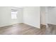 Neutral bedroom with hardwood floors, a large window, and adjacent door at 2925 Wild Olive Dr, St Cloud, FL 34772