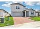 Charming two-story home with a well-manicured lawn and brick paver driveway at 2925 Wild Olive Dr, St Cloud, FL 34772