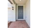 Covered front porch leads to a modern gray front door with a brick paver entry at 2925 Wild Olive Dr, St Cloud, FL 34772