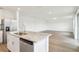 Open concept living room with durable floors and natural light from adjacent kitchen and exterior doors at 2925 Wild Olive Dr, St Cloud, FL 34772