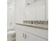 Bathroom featuring white vanity with gray granite countertop, toilet, tiled shower, and white walls at 2929 Wild Olive Dr, St Cloud, FL 34772
