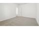 Bedroom with neutral carpet, white walls, baseboards, electrical outlets, and entrance to another room at 2929 Wild Olive Dr, St Cloud, FL 34772