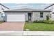 Beautiful single-Gathering home featuring stone and modern gray siding, landscaped yard, and a brick driveway at 2929 Wild Olive Dr, St Cloud, FL 34772