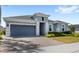 Charming single-story home featuring a well-manicured lawn, neutral paint, gray garage door, and a brick-paved driveway at 3347 Hanging Tide St, Winter Garden, FL 34787