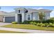 Charming single-story home featuring a well-manicured lawn, neutral paint, gray garage door, and a brick-paved driveway at 3347 Hanging Tide St, Winter Garden, FL 34787