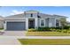 Charming single-story home featuring a well-manicured lawn, neutral paint, gray garage door, and a brick-paved driveway at 3347 Hanging Tide St, Winter Garden, FL 34787