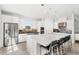 Bright, all-white kitchen featuring stainless steel appliances, an island with seating, and sleek countertops at 3347 Hanging Tide St, Winter Garden, FL 34787
