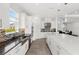 Bright, all-white kitchen featuring stainless steel appliances, an island with seating, and sleek countertops at 3347 Hanging Tide St, Winter Garden, FL 34787