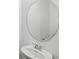 Close-up of a powder room showcasing a circular mirror and modern sink fixture at 3347 Hanging Tide St, Winter Garden, FL 34787