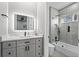 Stylish bathroom featuring an illuminated mirror, quartz countertops, gray cabinets, and modern shower-tub combo at 4205 Clarice Ct, Windermere, FL 34786