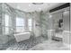Bright bathroom featuring marble walls, a modern tub, and a glass-enclosed shower with stylish tile at 4205 Clarice Ct, Windermere, FL 34786