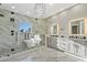 Modern bathroom with marble walls, a freestanding tub, a glass-enclosed shower, and a chandelier at 4205 Clarice Ct, Windermere, FL 34786
