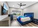 Cozy bedroom features a stylish blue bed, modern ceiling fan, and large window with natural light at 4205 Clarice Ct, Windermere, FL 34786