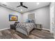 Neutral bedroom with gray walls, ceiling fan, a gray upholstered bed, and a comfy-looking armchair at 4205 Clarice Ct, Windermere, FL 34786