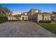 Elegant two-story home with stone accents, a three-car garage, and a large driveway at 4205 Clarice Ct, Windermere, FL 34786