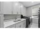 Clean laundry room featuring modern cabinets, a sleek countertop, and a front-load washer and dryer at 4205 Clarice Ct, Windermere, FL 34786