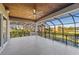 Expansive covered patio with a ceiling fan, wood ceilings, and wrought iron railings overlooking a lush landscape at 4205 Clarice Ct, Windermere, FL 34786