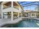 Spacious outdoor patio area with seating and outdoor kitchen overlooking custom pool at 4205 Clarice Ct, Windermere, FL 34786