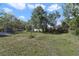Wide open backyard with towering mature trees providing nice shade, plus a storage shed on the property at 5719 Meridian Way, Orlando, FL 32808