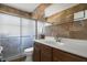 Beautiful bathroom featuring stone tile, a glass-enclosed shower, and a modern vanity at 5719 Meridian Way, Orlando, FL 32808