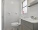 Cozy bathroom featuring a toilet, sink, tiled walls and natural light from a nearby window at 5719 Meridian Way, Orlando, FL 32808