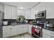 Modern kitchen with stainless steel appliances, granite countertops, and sleek white cabinets at 5719 Meridian Way, Orlando, FL 32808