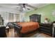 Spacious main bedroom with a large bed, green accent wall, and natural light at 5719 Meridian Way, Orlando, FL 32808