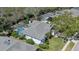 An aerial view of the home showing the roof, screened-in pool, lawn, and surrounding mature trees at 5776 Falling Tree Ln, Port Orange, FL 32127