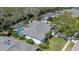 An aerial view of the home showing the roof, screened-in pool, lawn, and surrounding mature trees at 5776 Falling Tree Ln, Port Orange, FL 32127