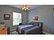 Comfortable bedroom with a gray bedspread, modern light fixture and plenty of natural light from the window at 5776 Falling Tree Ln, Port Orange, FL 32127