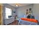 Charming bedroom featuring blue walls, wood floors, a ceiling fan and an abundance of natural light at 5776 Falling Tree Ln, Port Orange, FL 32127