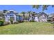 Charming single-story blue home featuring a manicured lawn and tropical palm tree accents at 5776 Falling Tree Ln, Port Orange, FL 32127