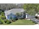 Aerial view of a well-maintained home with lush landscaping, a two-car garage, and a light blue exterior at 5776 Falling Tree Ln, Port Orange, FL 32127