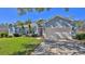 Charming single-story home featuring a well-manicured lawn, attached garage, and palm tree accents at 5776 Falling Tree Ln, Port Orange, FL 32127