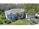 Aerial view of a well-maintained home with lush landscaping, a two-car garage, and a light blue exterior at 5776 Falling Tree Ln, Port Orange, FL 32127