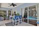 This covered patio features an outdoor seating area and a peek at the screened in pool at 5776 Falling Tree Ln, Port Orange, FL 32127