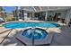 Inviting screened-in pool and hot tub with lots of patio space for entertaining and enjoying the Florida weather at 5776 Falling Tree Ln, Port Orange, FL 32127