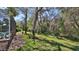 Mature landscaping borders a lush green yard with a screened-in patio offering privacy and shade at 5776 Falling Tree Ln, Port Orange, FL 32127