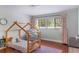 Charming bedroom featuring hardwood floors, natural light, and wooden toddler bed at 643 Woodridge Dr, Fern Park, FL 32730
