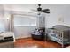 Cozy Bedroom with dark ceiling fan, hardwood floors, window with curtains, and rocking chair at 643 Woodridge Dr, Fern Park, FL 32730