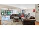 Inviting living room featuring a plush leather sofa, neutral rug, and plenty of natural light from sliding glass doors at 643 Woodridge Dr, Fern Park, FL 32730