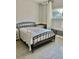 Bedroom with a wrought iron bed frame, neutral colors, and shuttered windows at 7112 Enchanted Lake Dr, Winter Garden, FL 34787