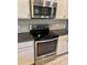 Modern kitchen with stainless steel oven/range, granite counters and white cabinets at 7112 Enchanted Lake Dr, Winter Garden, FL 34787