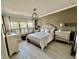 Main bedroom with a large window, neutral walls and an upholstered headboard bed at 7112 Enchanted Lake Dr, Winter Garden, FL 34787