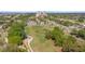 Aerial view of a residential community, featuring yellow homes, a golf course, and lush landscaping at 7512 Seven Eagles Way # 7512, Reunion, FL 34747